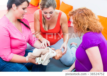 Midwife explaining birth process to pregnant women Midwife explaining birth process to pregnant women 38524752