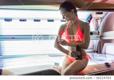 Beautiful woman applying nutritive oil on her skin Beautiful woman applying nutritive oil on her skin 38524765
