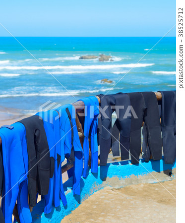 Surfing wetsuits drying on beach Surfing wetsuits drying on beach 38525712