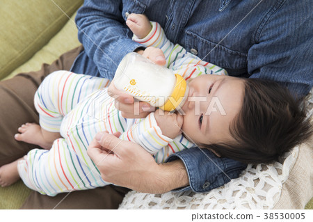 Daddy giving milk to baby Daddy giving milk to baby 38530005