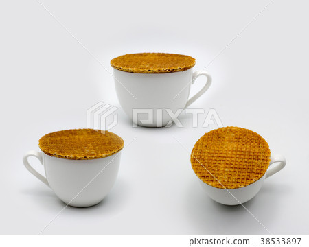 stroop waffles Dutch style streaming on ceramic cup on white bac stroop waffles Dutch style streaming on ceramic cup on white bac 38533897