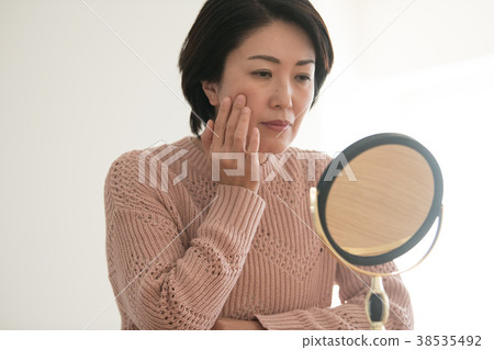 看鏡子的中間婦女小心皮膚 38535492