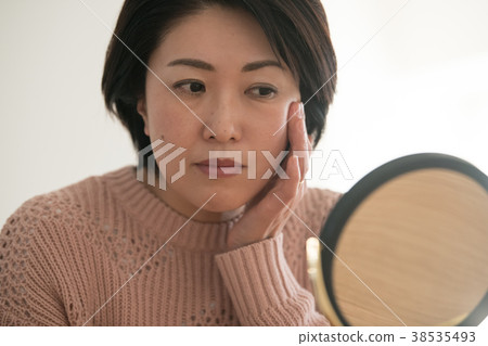 看鏡子的中間婦女小心皮膚 38535493