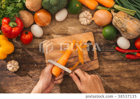 Cutting carrot. Male hands cooking vegetables  Cutting carrot. Male hands cooking vegetables  38537135