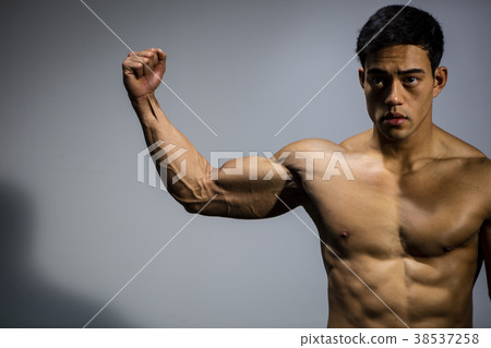 Asian Fitness Model Flexes Bicep Muscle 38537258
