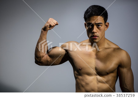 Asian Fitness Model Flexes Bicep Muscle 38537259