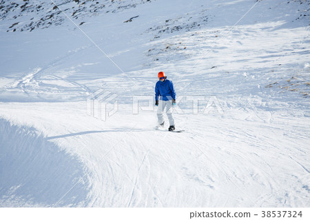 Photo of man in helmet riding snowboard from snowy 38537324