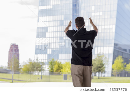 Man Pointing at Skyscraper Buildings Rear View 38537776