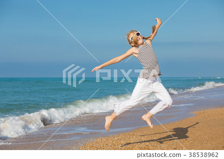 One happy little girl playing on the beach at the day time 38538962