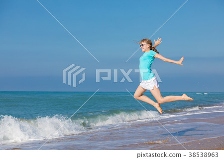 teen girl jumping on the beach at blue sea shore in summer vacat teen girl jumping on the beach at blue sea shore in summer vacat 38538963