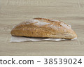 SIDE VIEW OF CRUSTY LOAF ON A WOOD TABLE 38539024