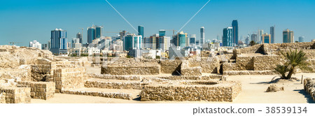 Ruins of Bahrain Fort with skyline of Manama. A Ruins of Bahrain Fort with skyline of Manama. A 38539134
