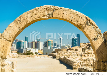 Ancient arch at Bahrain Fort with skyline of 38539139