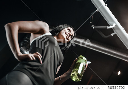 Sexy athletic young girl takes sport nutrition Sexy athletic young girl takes sport nutrition 38539702