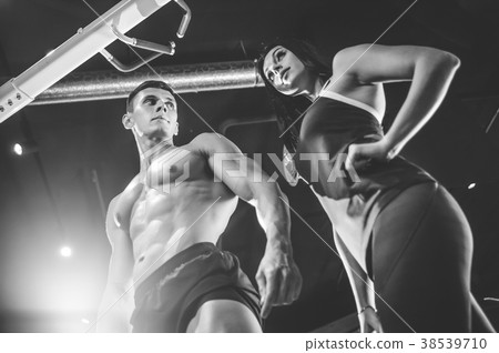 Model young man and woman working out in gym Model young man and woman working out in gym 38539710