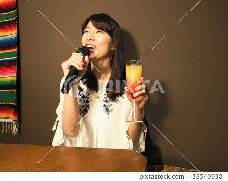 唱歌在與雞尾酒的卡拉OK演唱的婦女 38540938