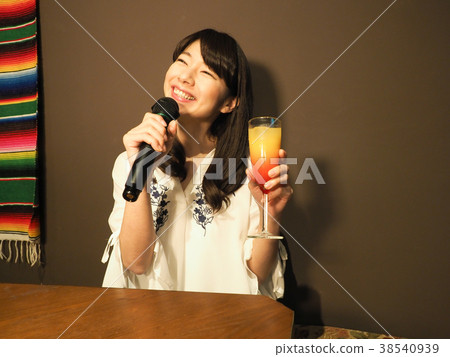 唱歌在與雞尾酒的卡拉OK演唱的婦女 38540939