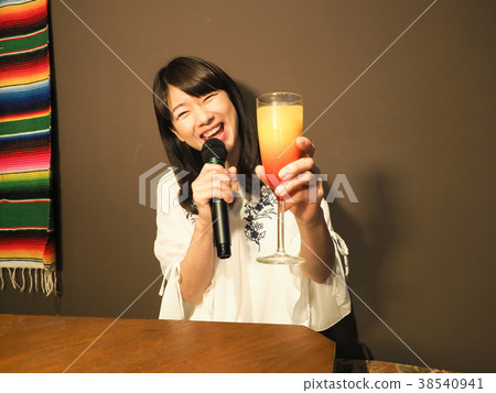 Woman singing in karaoke with a cocktail 38540941