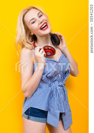 Blonde girl in blue striped blouse with headphones Blonde girl in blue striped blouse with headphones 38541203