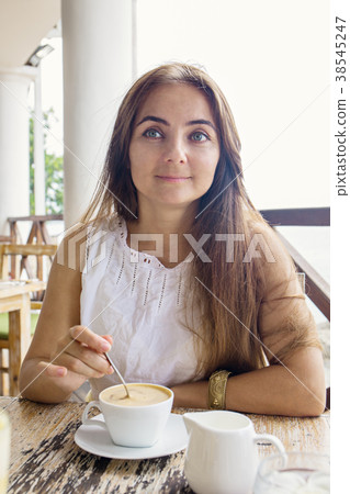 A woman is drinking cappuccino A woman is drinking cappuccino 38545247