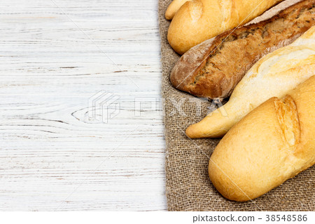 Loaf of bread on a white rustic table. baguette Loaf of bread on a white rustic table. baguette 38548586