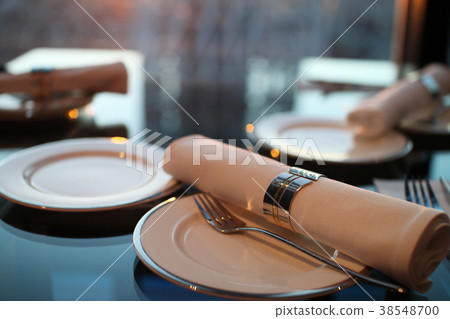 Table setting at a restaurant with a sunset 38548700
