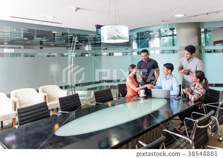 Multi-ethnic team of employees watching a funny Multi-ethnic team of employees watching a funny 38548881