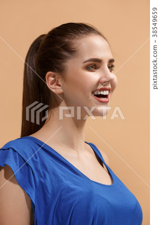 The happy woman standing and smiling against 38549659