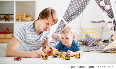 happy family father and son playing in toy car in playroom 38550702