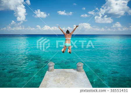 One woman jump in blue water One woman jump in blue water 38551431
