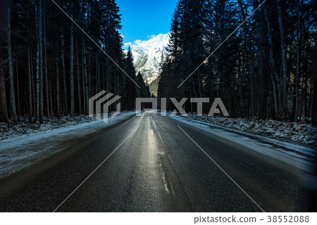 Road through winter mountain forest 38552088