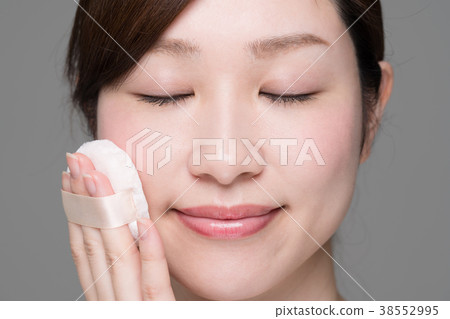 Woman doing makeup, foundation, puff, sponge Woman doing makeup, foundation, puff, sponge 38552995