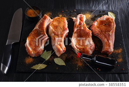 raw pork chops seasoned with spices raw pork chops seasoned with spices 38558351