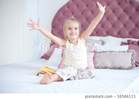 Cute little blond girl lying on bed Cute little blond girl lying on bed 38566115