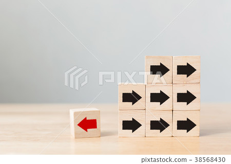 Wooden block with red arrow facing the opposite 38568430