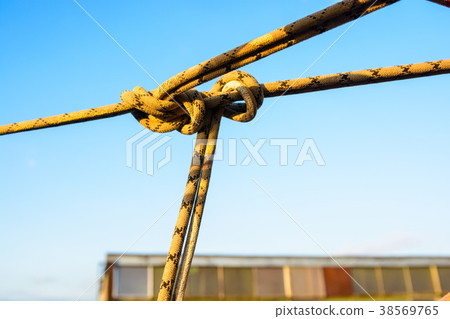 Closeup stretched and tied industrial braided rope Closeup stretched and tied industrial braided rope 38569765