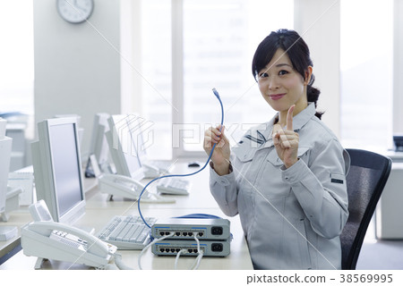 Woman in work clothes with LAN cable Woman in work clothes with LAN cable 38569995