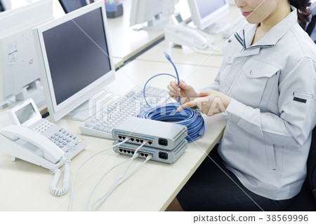 工作服的婦女有LAN纜繩的 工作服的婦女有LAN纜繩的 38569996