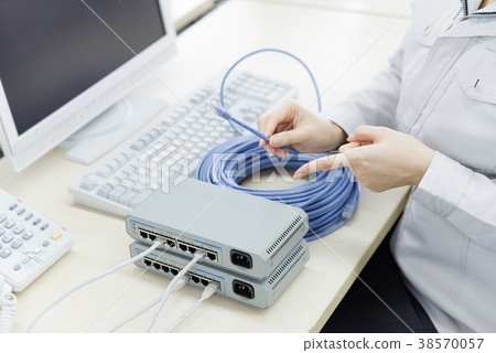Woman in work clothes with LAN cable Woman in work clothes with LAN cable 38570057