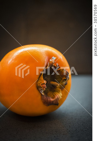 Diospyros kaki, persimmon fruit on dark background 38570569