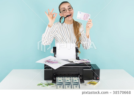 Attractive woman prints cash with magnifying glass 38570668