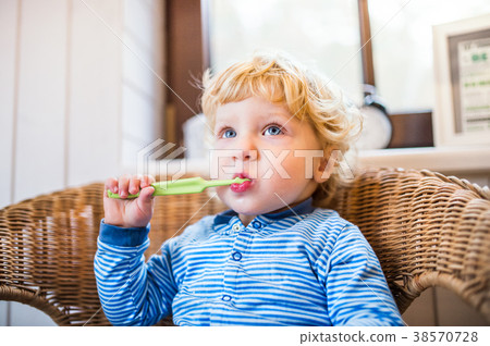 Cute toddler boy brushing his teeth in the 38570728