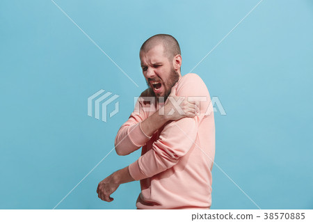 Young man overwhelmed with a pain in the shoulder 38570885