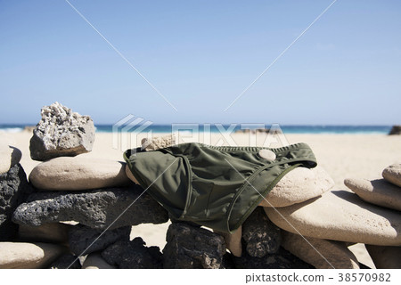 mens swuimsuit drying on the beach 38570982