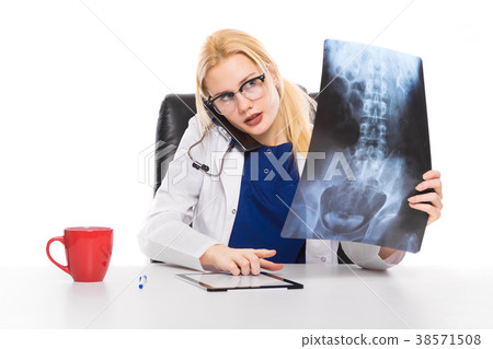 Woman doctor in white coat carefully studies X-ray 38571508
