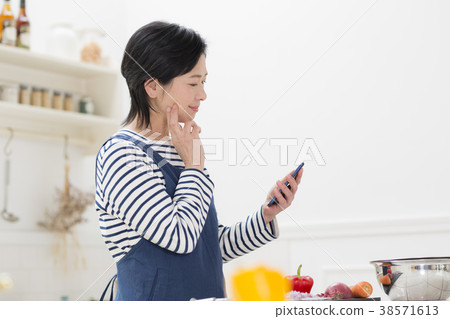 Housewife examining a menu with a smartphone Housewife examining a menu with a smartphone 38571613