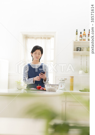 Housewife examining a menu with a smartphone Housewife examining a menu with a smartphone 38571614
