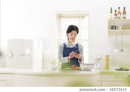Housewife examining a menu with a smartphone 38571615