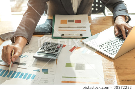 Men wearing suits using a pen pointing on graph. Men wearing suits using a pen pointing on graph. 38572252