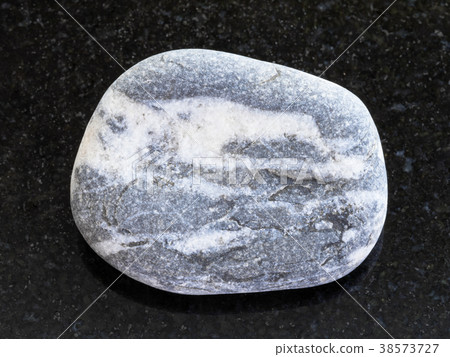 pebble of gray Gneiss stone on dark 38573727